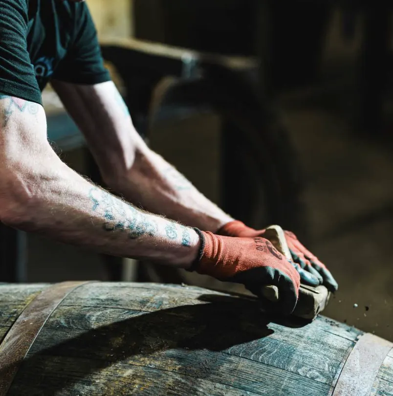 Artisan tonnelier travaillant une barrique de chêne à la main